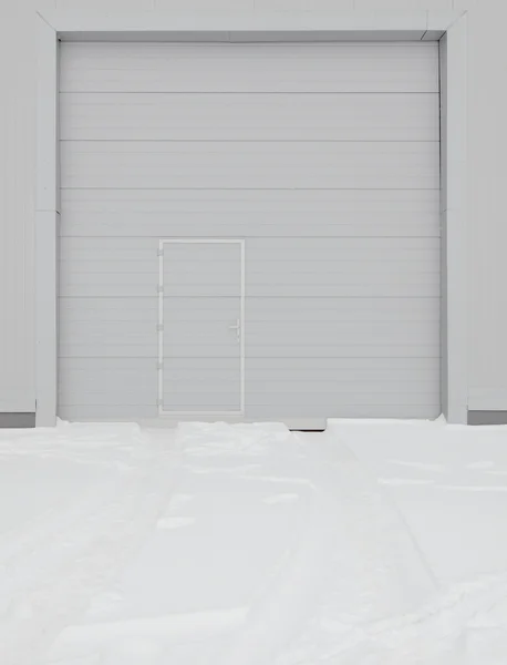 Simple metal door in gray wall — Stock Photo, Image