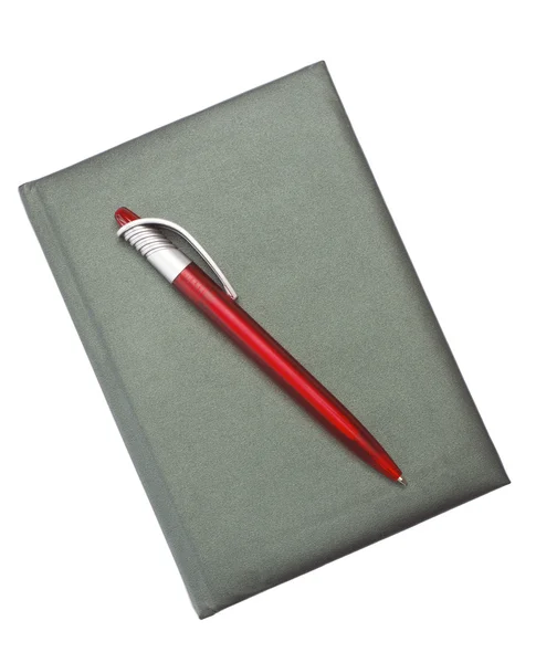 Caneta vermelha em um caderno escuro — Fotografia de Stock