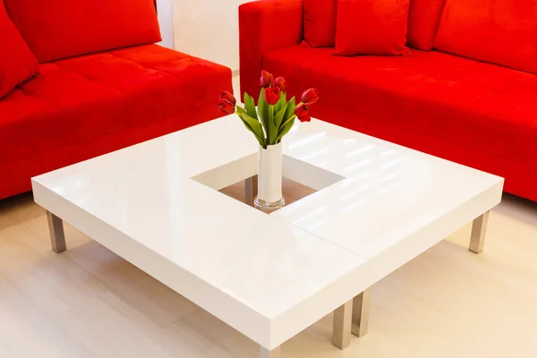 Mesa moderna con flores rojas - interior del hogar en tono blanco —  Fotos de Stock