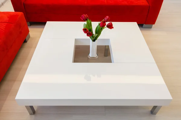 Mesa moderna con flores rojas - interior del hogar en tono blanco —  Fotos de Stock