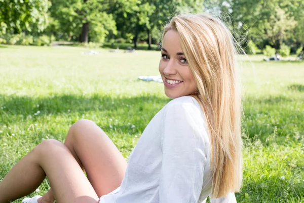 Mulher branca sorrindo feliz no verão ensolarado ou dia de primavera fora no parque — Fotografia de Stock