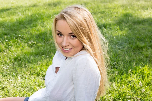 Mulher branca sorrindo feliz no verão ensolarado ou dia de primavera fora no parque — Fotografia de Stock