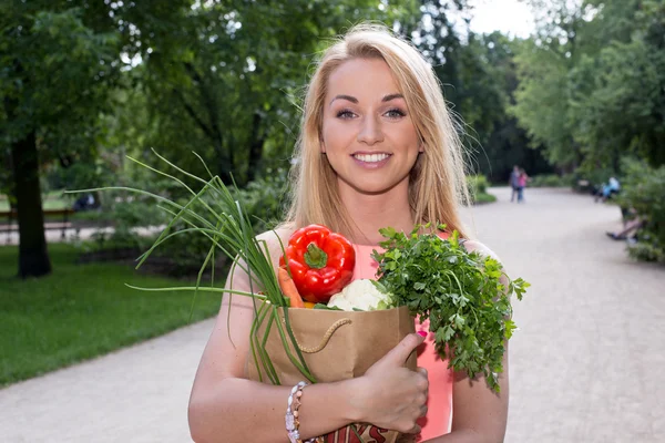 Fiatal nő, egy élelmiszerbolt bevásárló táska — Stock Fotó