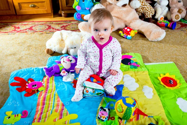 Bébé sur le tapis avec des jouets — Photo