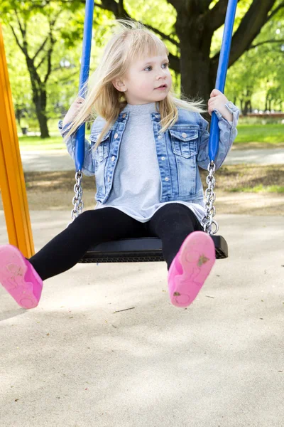 Little girl on outdoor playground equipment — Stock Photo, Image