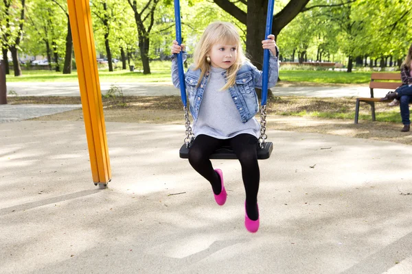 Little girl on outdoor playground equipment — Stock Photo, Image