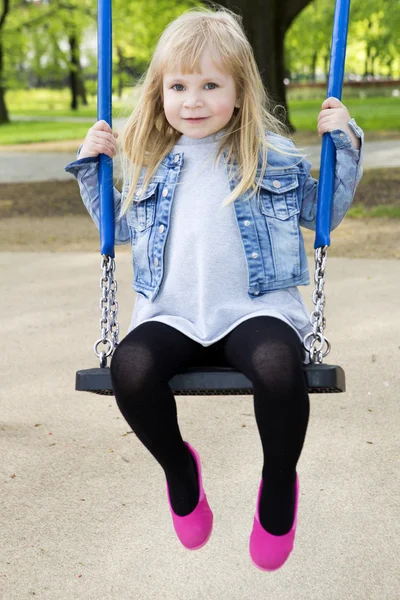 Liten flicka på utomhus lekplatsutrustning — Stockfoto
