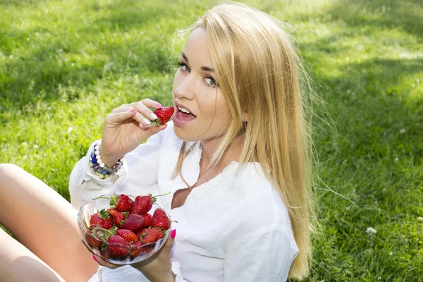 A beautiful young girl with strawberries outdoor — Stock Photo, Image