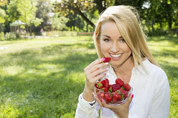 A beautiful young girl with strawberries outdoor — Stock Photo, Image