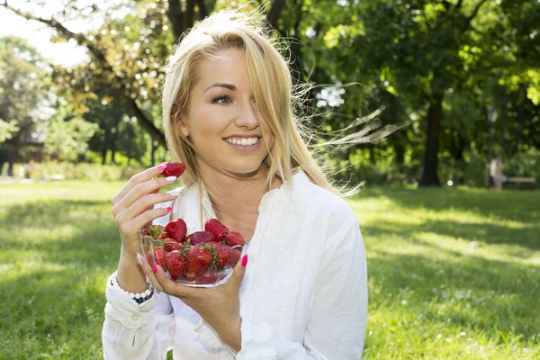 A beautiful young girl with strawberries outdoor — Stock Photo, Image