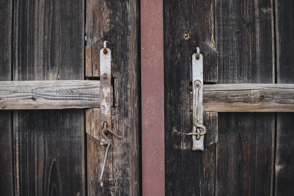 閉鎖に使われる金属製のフックを持つ古い木製のドアの詳細 — ストック写真