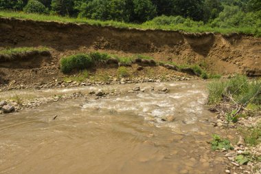 effects of a river erosion process in a hilly terrain