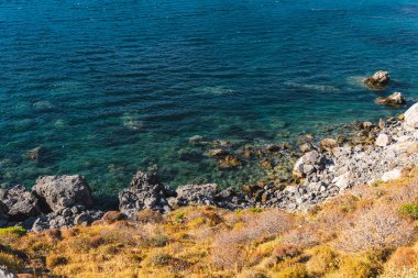 a section of the steep rocky coastline of the Mediterranean Sea on the island of Crete