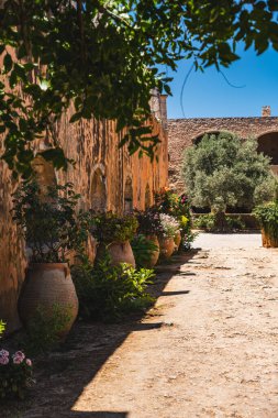 Üzerinde kilden vazolar bulunan tarihi bir binanın duvarı.