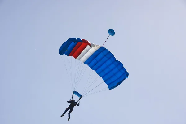 Fallschirmspringer springt vor blauem Himmel — Stockfoto