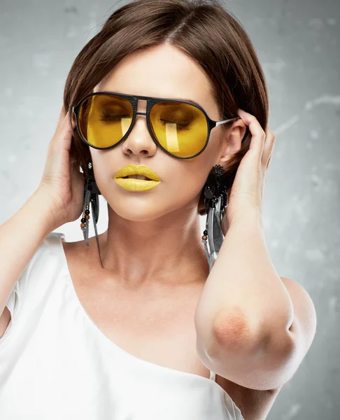 Mujer joven en gafas de sol amarillas — Foto de Stock