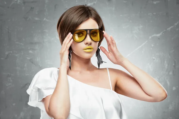 Mujer joven con gafas de sol amarillas — Foto de Stock
