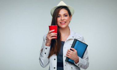 Beyaz ceketli, elinde büyük kırmızı kahve fincanı ve kitapları olan bir bayan öğrenci. soyutlanmış kadın portresi.