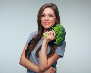 Elinde brokoli tutan genç bir kadın. soyutlanmış kadın portresi.