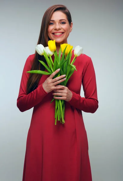 チューリップの花を保持赤いドレスの幸せな女性 歯の笑顔の孤立した肖像画を持つ女の子 — ストック写真