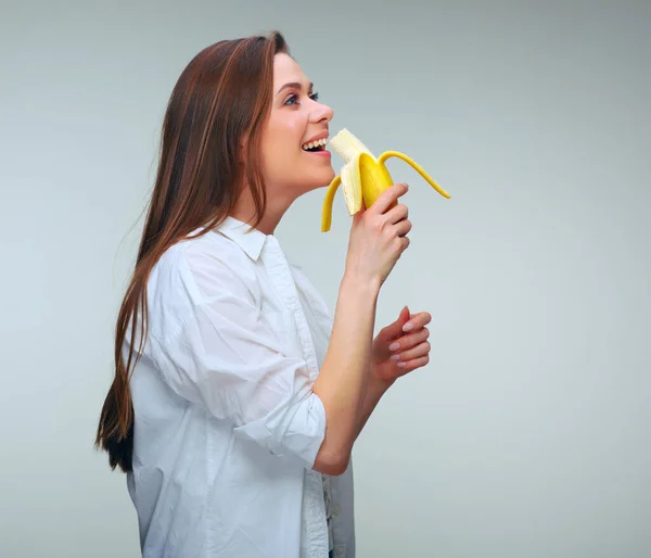 カジュアルなバナナを食べ 離れて見て服を着た女性 孤立した女性の肖像 — ストック写真