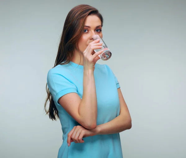 女性はガラスから水を飲む 青いドレスを着た笑顔の女性の隔離された女性 — ストック写真