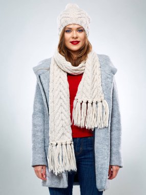 Örgü şapka ve eşarp takmış, kışlık yünlü ceketle poz veren gülen kadın. Kışlık ceketli, izole kadın portresi.