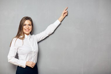 Kendine güvenen iş kadını gri kopya alanını işaret ediyor. Stüdyo resmi.