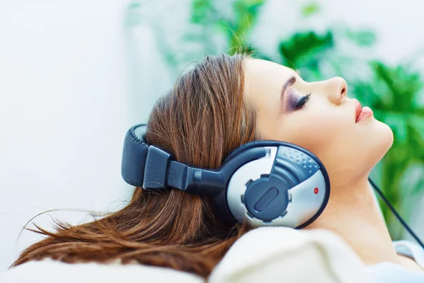 Mujer dormida en casa con auriculares —  Fotos de Stock