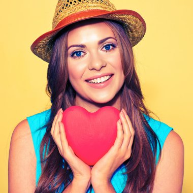 Genç bir kadın kırmızı kalp taşıyor..