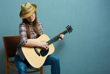 Kadın gitar çalıyor.