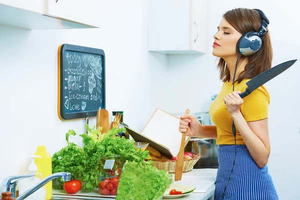 Mulher cozinhar com fones de ouvido — Fotografia de Stock