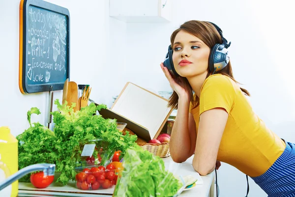 Femme cuisine avec écouteurs — Photo