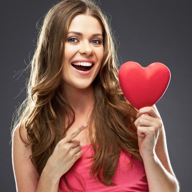 Kırmızı kalp tutan gülümseyen kadın