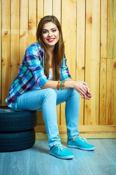 Donna seduta su pneumatici auto — Foto Stock