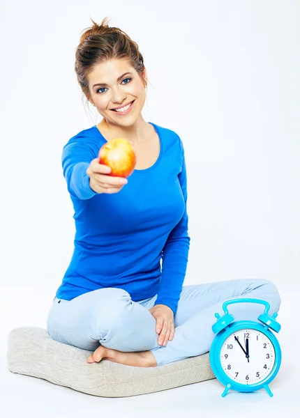 Woman sitting on pillow with apple — Stock Photo, Image