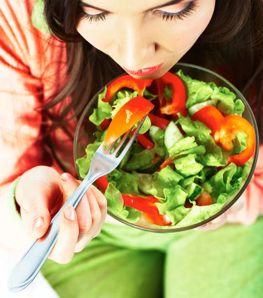 Vrouw eet groene salade — Stockfoto