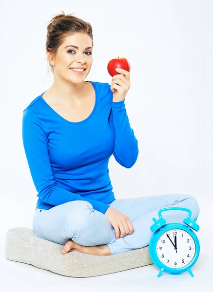 Femme assise sur un oreiller avec une pomme — Photo