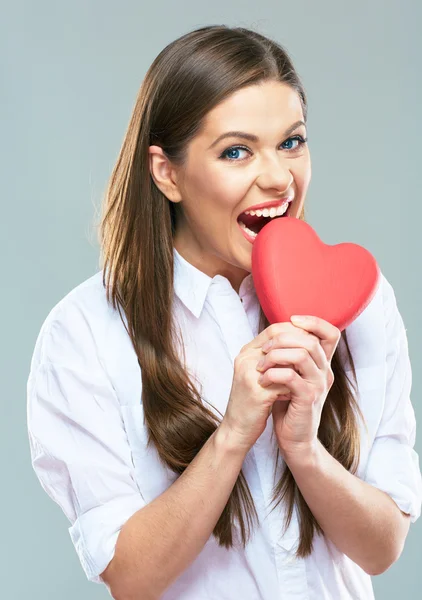 Woman biting red heart — Stock Photo, Image