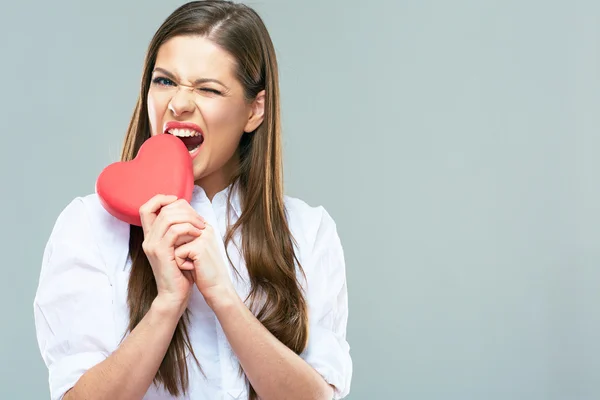 Жінка кусає червоне серце — стокове фото