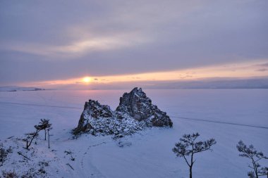 Olkhon Adası 'ndaki Burkhan Burnu' nda Şaman Kayası 'nın yanında gün batımı. Baykal, Irkutsk bölgesi, Rusya