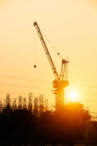 Lugar de construcción y pilón eléctrico al atardecer — Foto de Stock