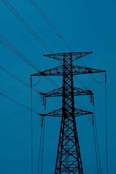 Electricity pylon above urban rooftops — Stock Photo, Image