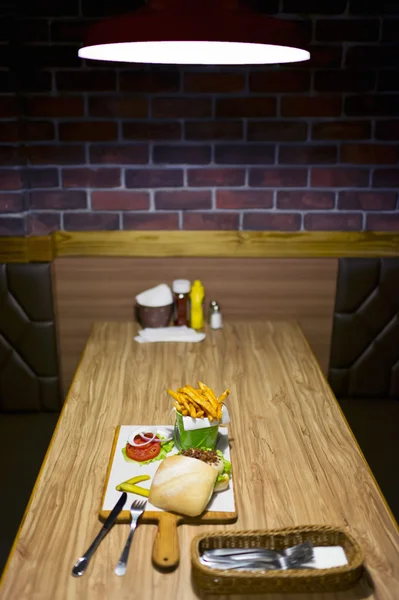 Heerlijke vierkante hamburger en chips op restaurant tabel — Stockfoto