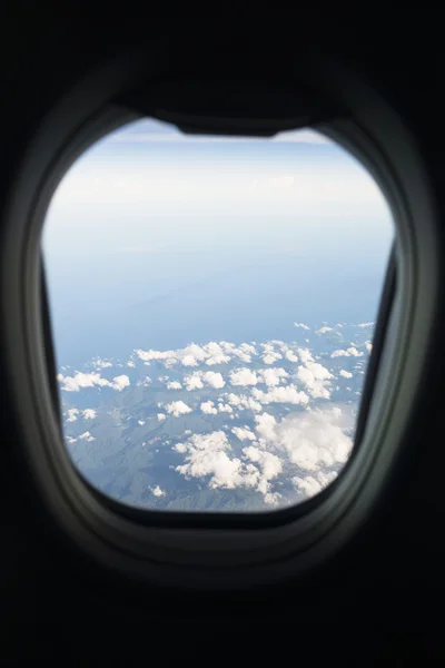 Clássico céu azul e nuvens vista através da janela do avião . — Fotografia de Stock