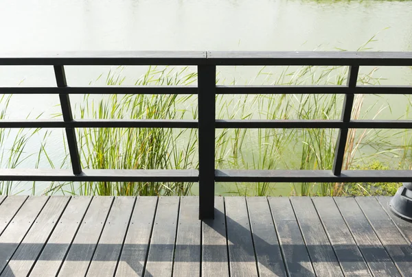 Shlížel na zábradlí balkónu nebo Boardwalk čelí rybník s — Stock fotografie