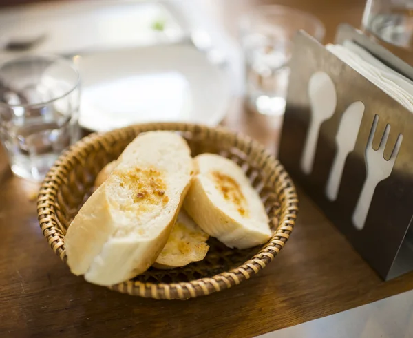 Oranje pompoenen in rieten mand naast venster — Stockfoto