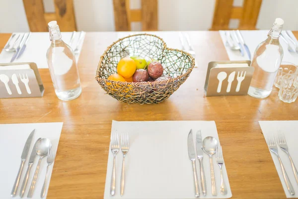 Frutas em forma de coração cesta na mesa de jantar com louça — Fotografia de Stock