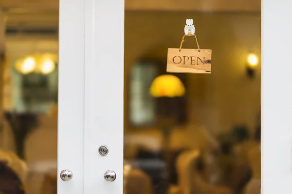 Πινακίδα "ανοιχτά" κρέμεται στην πόρτα ενός καταστήματος. — Φωτογραφία Αρχείου