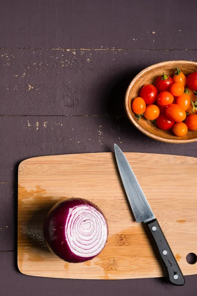 Componentes frescos- cebolla y tomates cherry para cocinar en woode — Foto de Stock